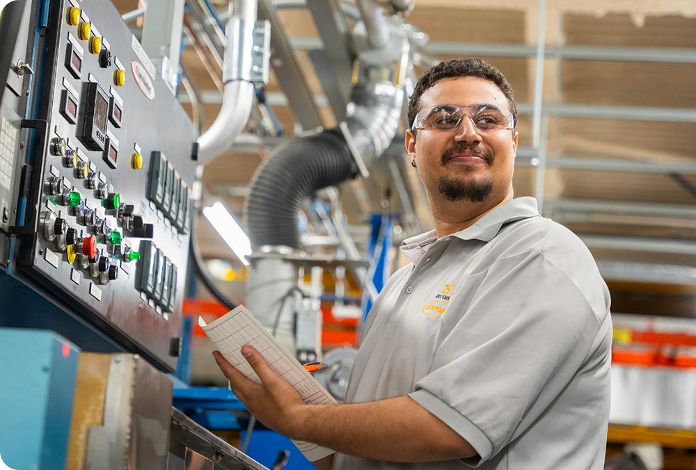 Smiling operator at a control panel in the plant