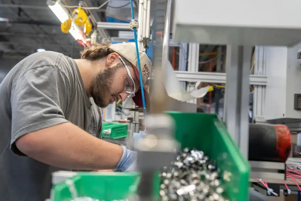 Assembler wearing safety glasses at work on an Innovair production line