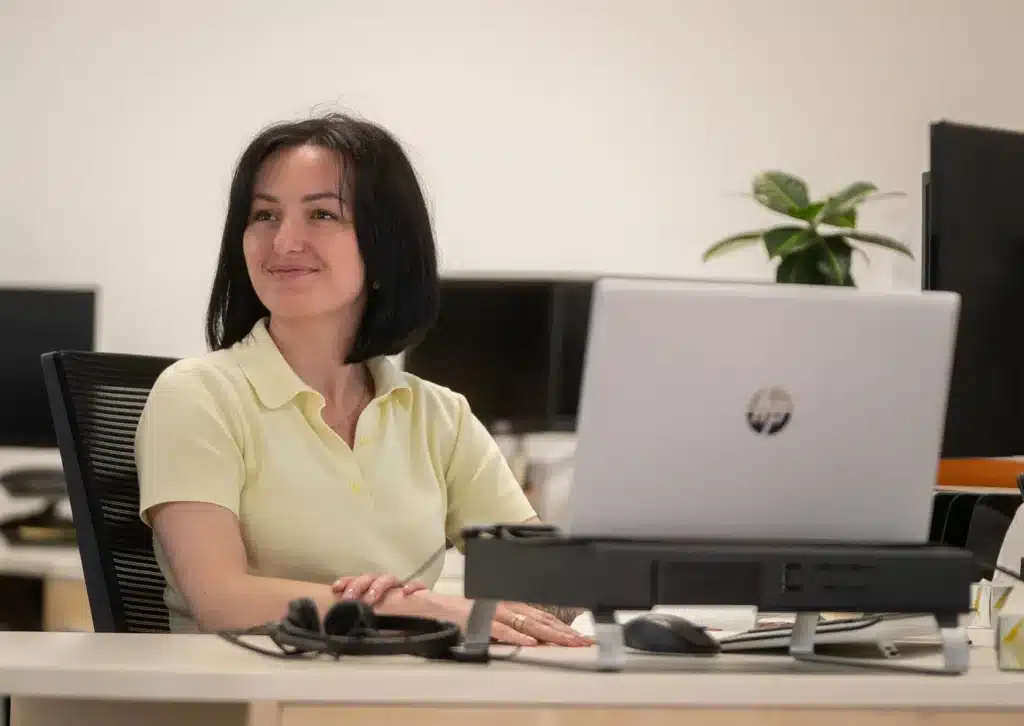 Stelpro team member smiling at a workstation with a laptop
